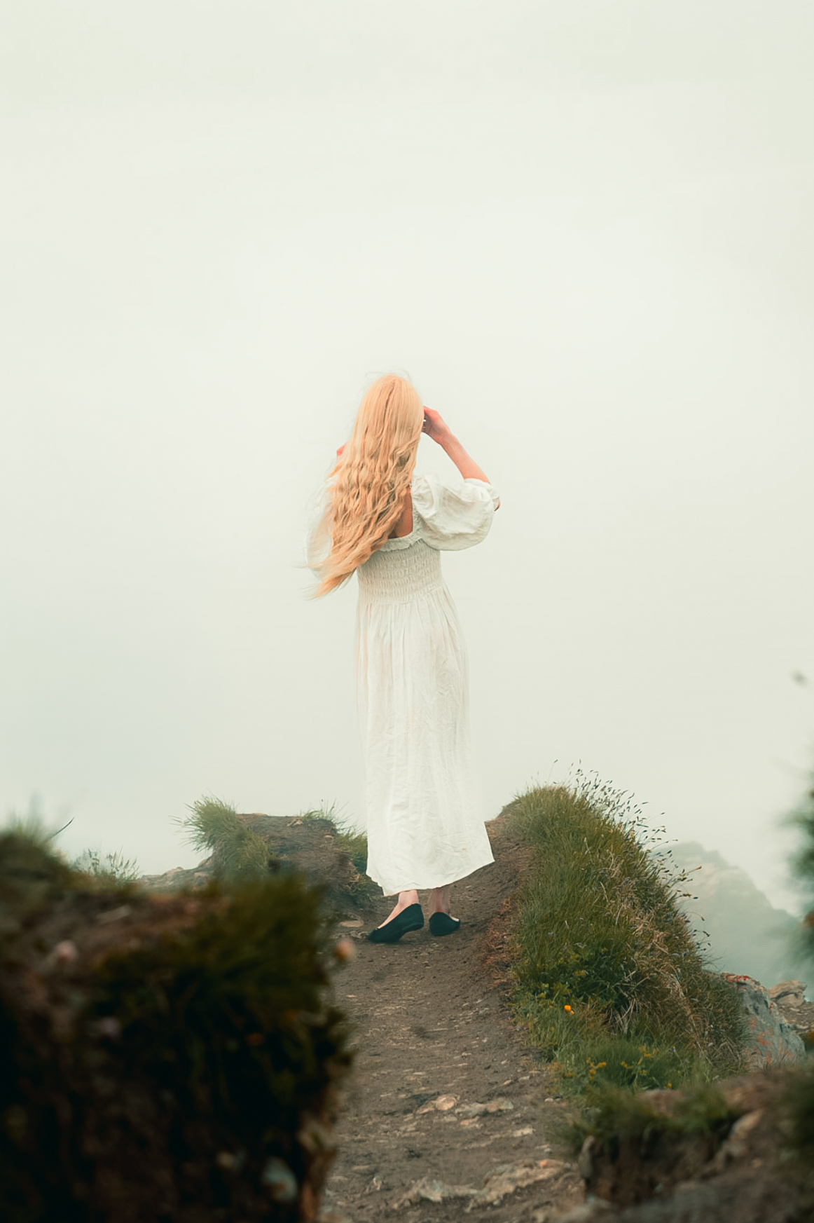 Editorial luxury lifestyle portrait of woman in white dress on hilltop, photograph by Simone Slawitz
